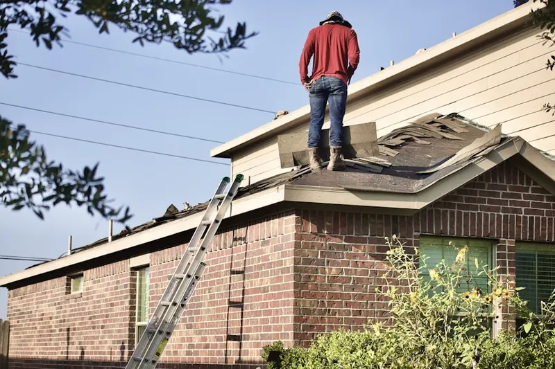 Professional roofer working on a residential roof in Rodman